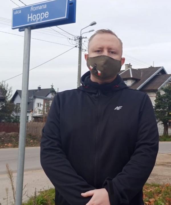 mężczyzna na tle tablicy informacyjnej